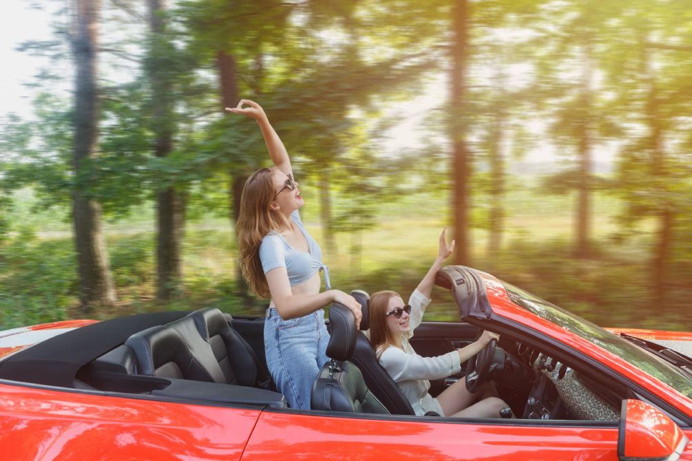 オープンカーでノリノリな女性達